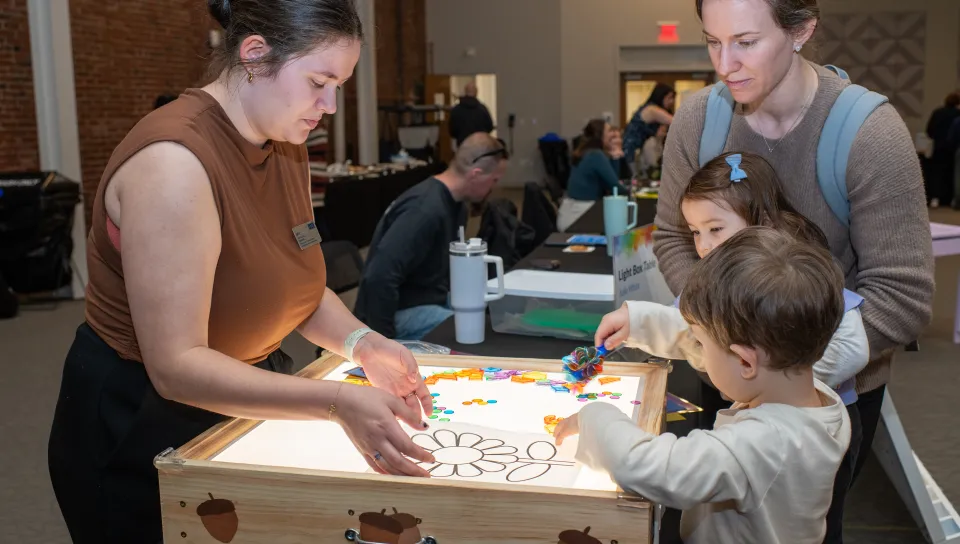 Children play with a student's light-up sensory board
