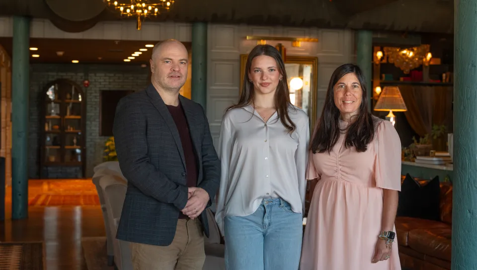 UNE business leaders and a student pose inside The Lincoln Hotel lobby