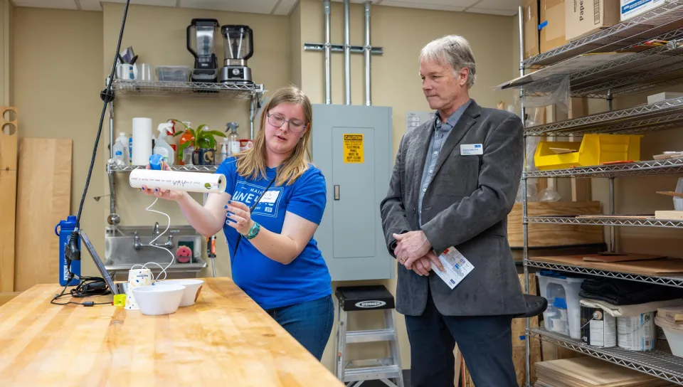 A student displays a marine research device fashioned from PVC pipes