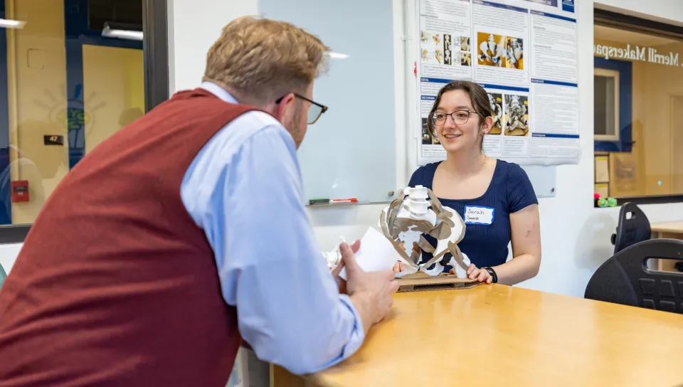 A student talks with an event attendee about their project