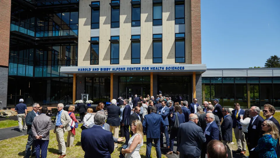 A crowd gathers on the lawn of the Harold and Bibby Alfond Center for Health Sciences