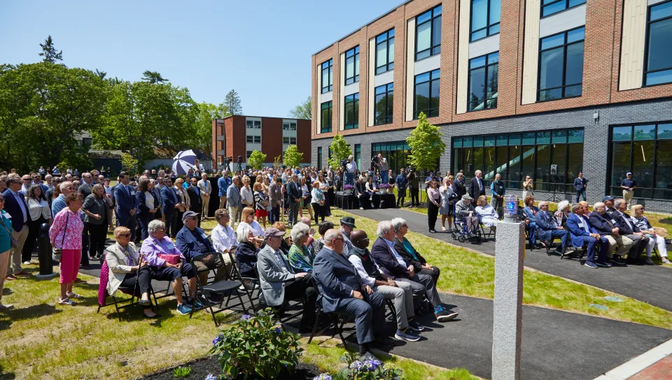 A crowd gathers on the lawn of the Harold and Bibby Alfond Center for Health Sciences