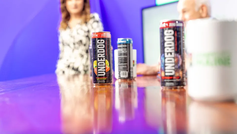 A lineup of Underdog Performance Drinks and Greenlight Maine coffee mugs