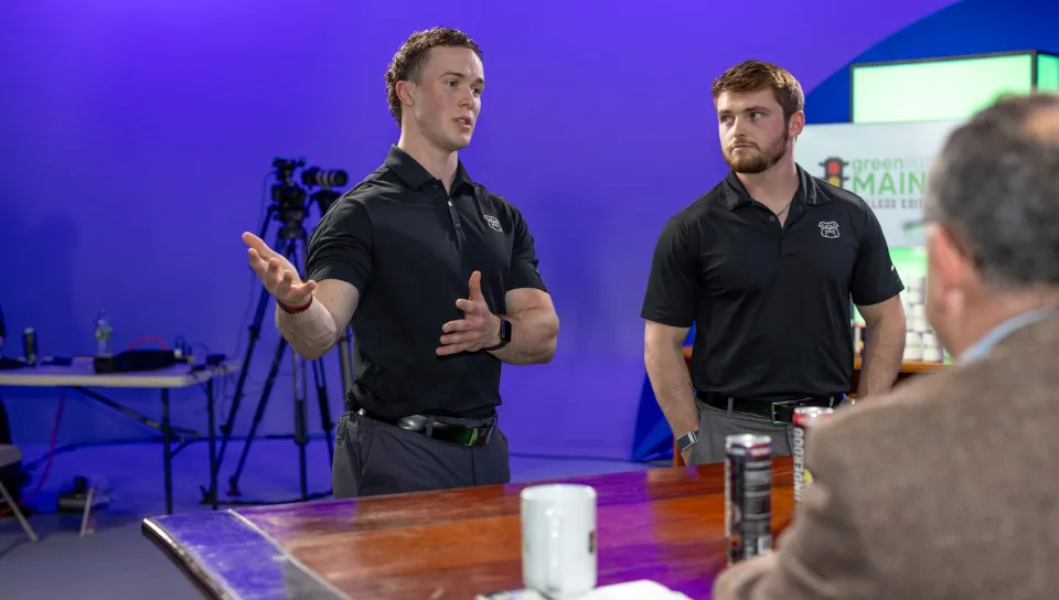 Two UNE students present their product to a panel of judges