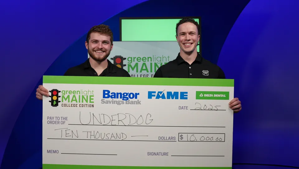 Joey Stanizzi and Dylan Schuett ’25 hold a large check for their Greenlight Maine win