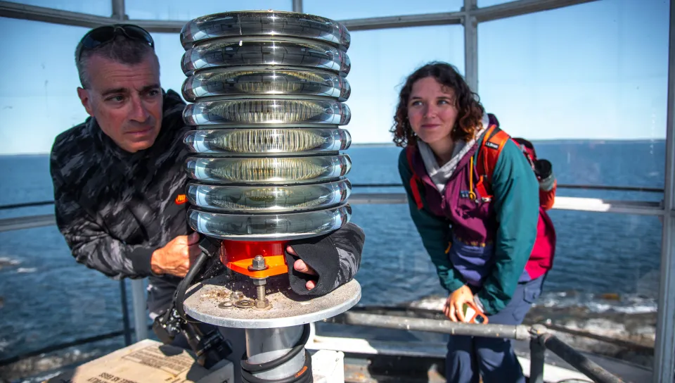 Bob Trapani and Regina Dyer test the lens of Halfway Rock lighthouse
