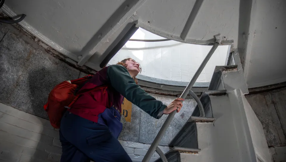 Regina Dyer peers into the lantern room of Halfway Rock Light Station