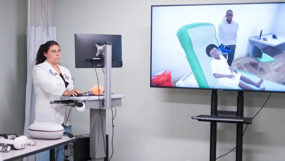 A C O M student uses a computer program to learn how to care for a patient