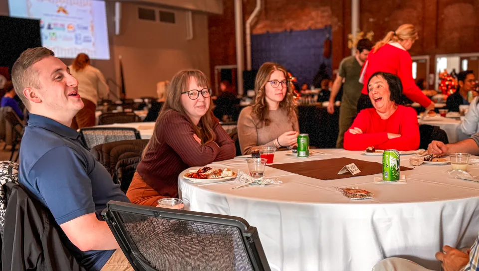 Employees smile around a lunch table in Innovation Hall