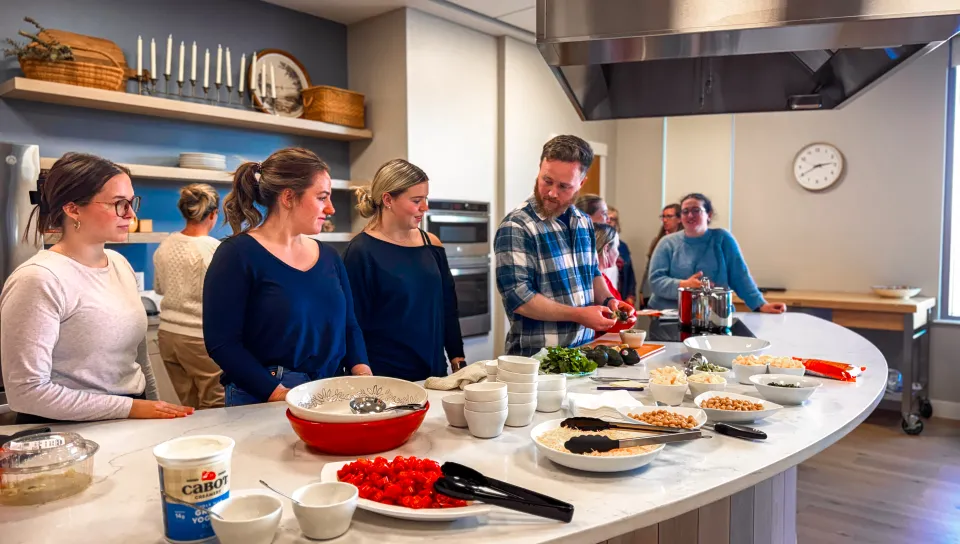 Students cook together in a demonstration kitchen