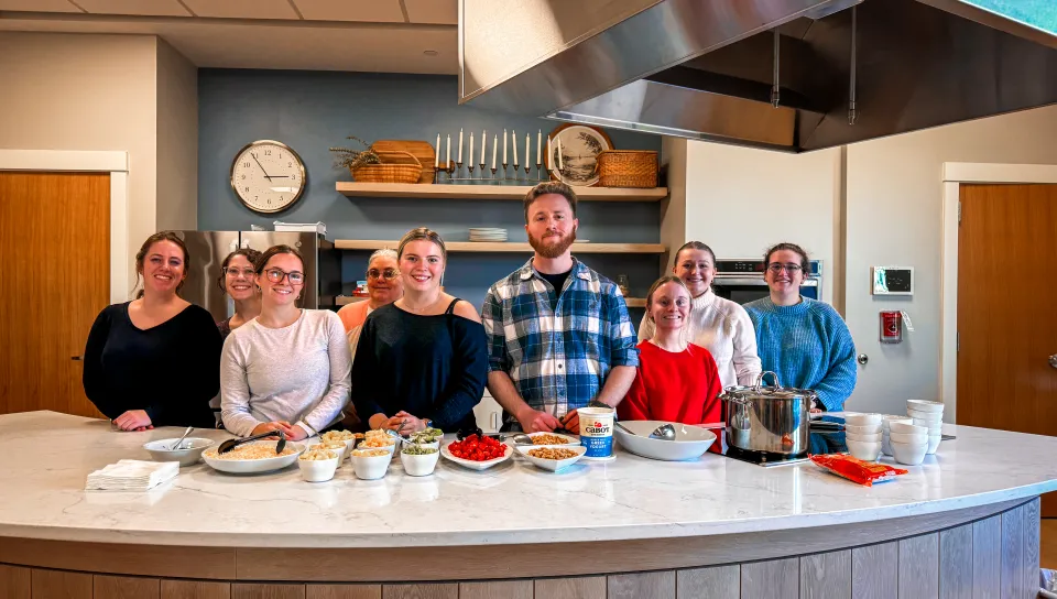 Student volunteers pose behind a kitchen island
