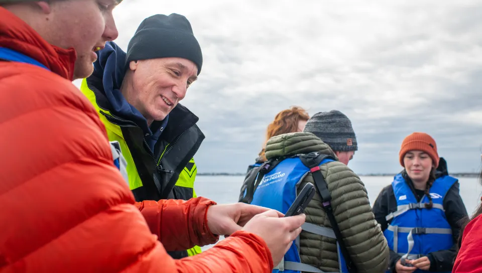 Dr. Will Kochtitzky shows a UNE pilot ocean data on his smartphone