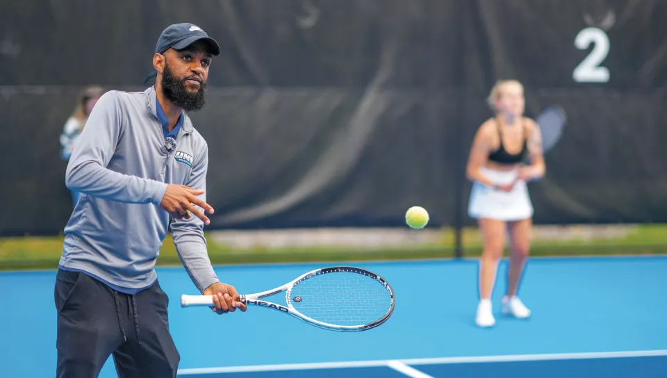Coach Jovan Jordan-Whitter prepares to serve tennis balls during practice at UNE's outdoor tennis facility on Old Pool Road in Biddeford.
