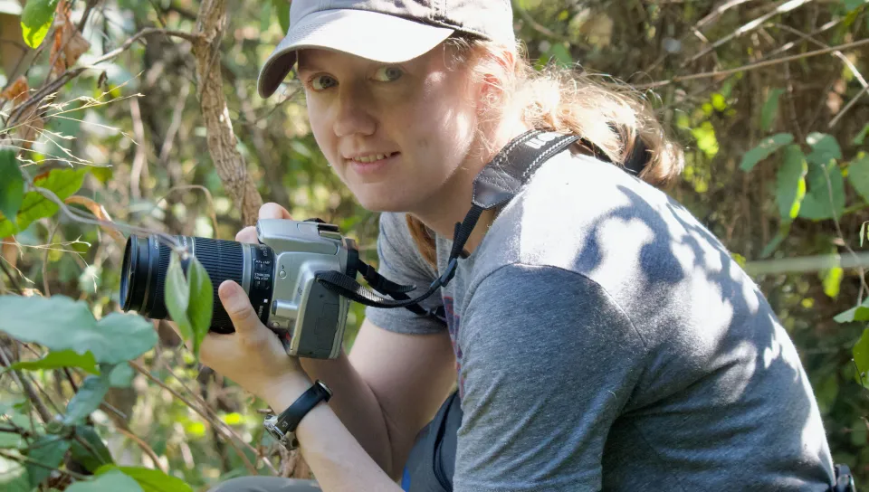 UNE faculty member Maggie Stanton holds a camera in Gombe National Park