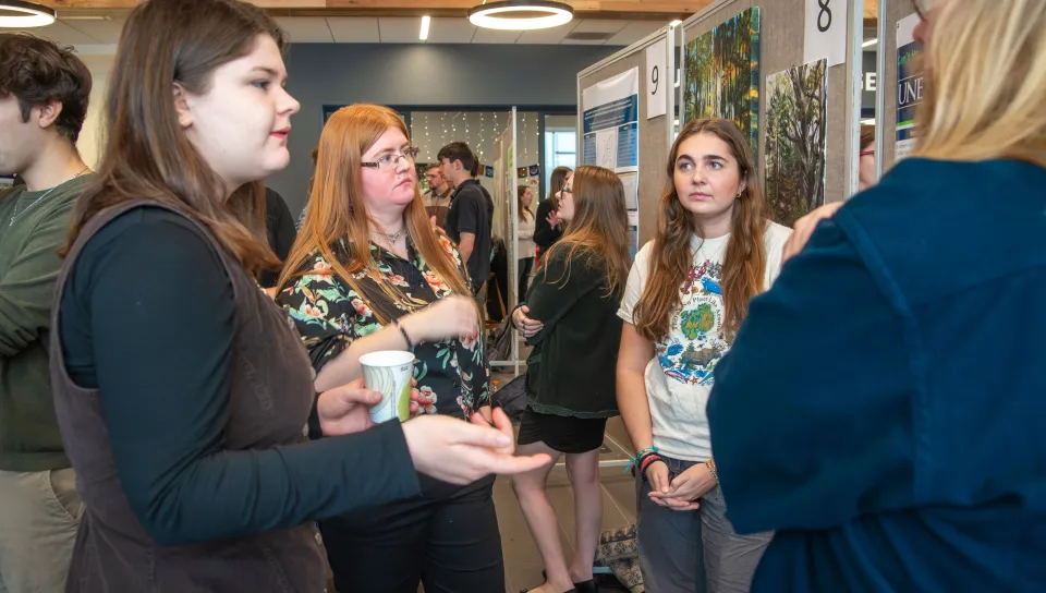 students chatting at University of New England’s Fall Art and Research Symposium