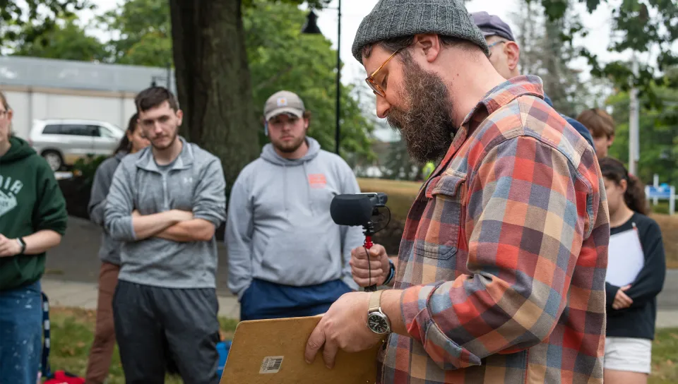 Eric Zuelow demonstrates archaeological techniques to UNE students during a field session for the Time Team New England course on the Biddeford Campus.