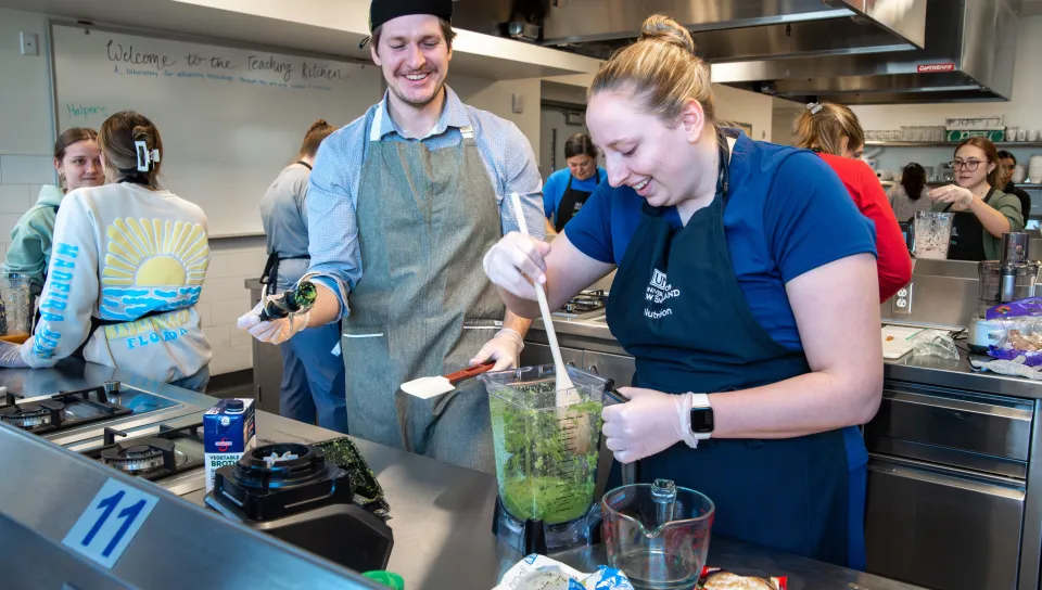 Two occupational therapy students examine a mixture of blended broccoli as part of a team exercise