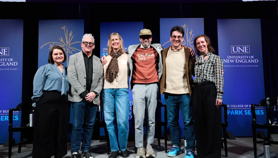 A group of people pose for a photo onstage