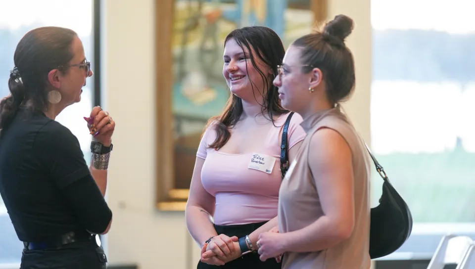 Mary Allen Lindemann speaking to two UNE students