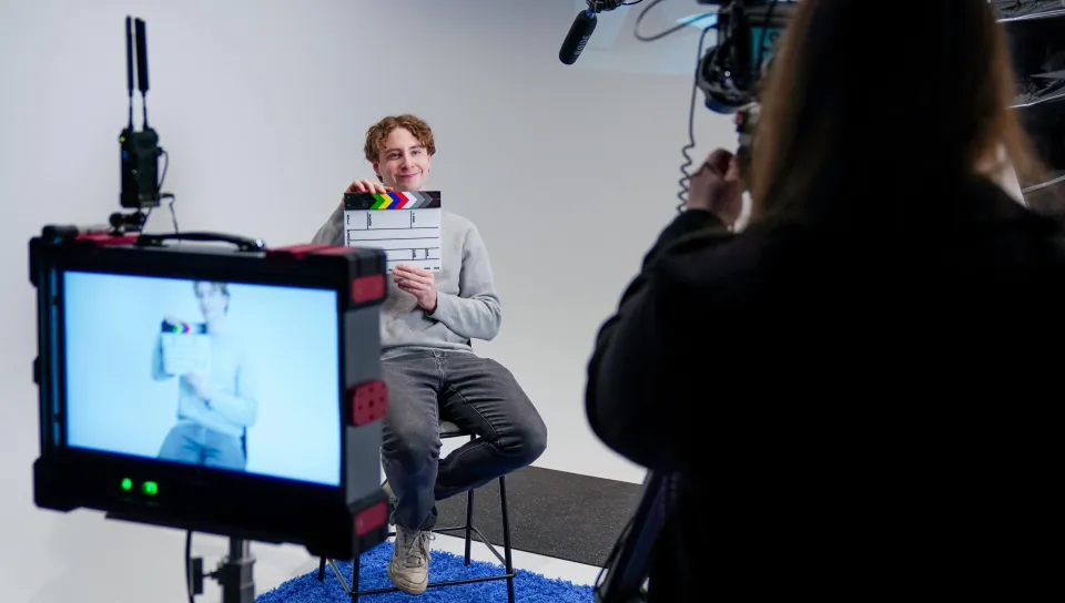 A UNE student claps a slate in UNE's Production Studio