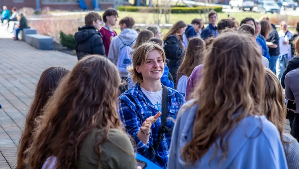 A U N E student guide shows visitors around campus
