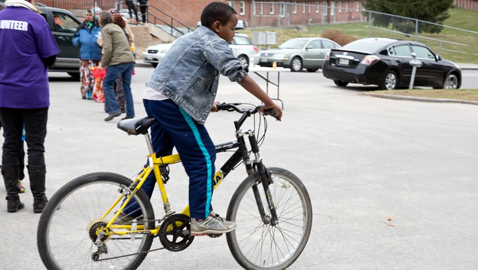 A kid riding a bicycle on pavement