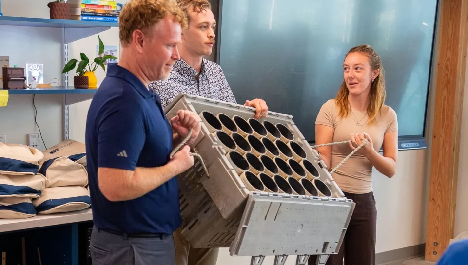 Marine science students present a green crab enclosure