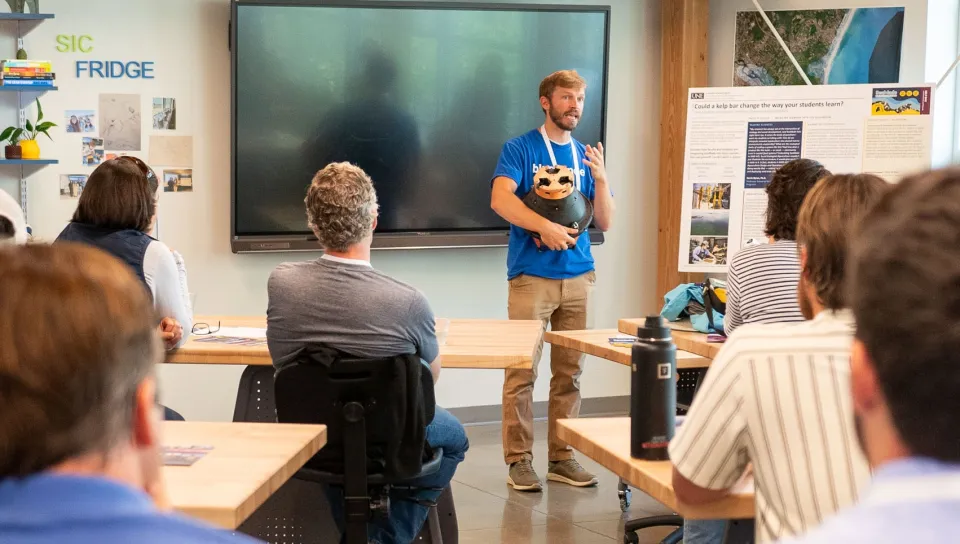 A presenter displays ocean monitoring equipment