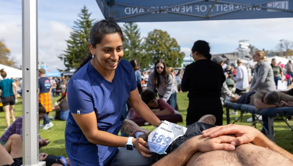A UNE medical student evaluates a runner after a marathon