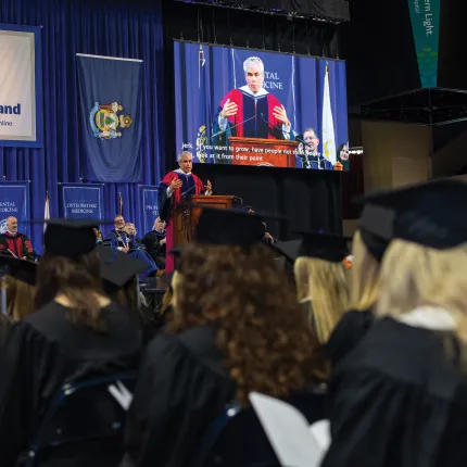 Students watch as a speaker gives the 2022 commencement address