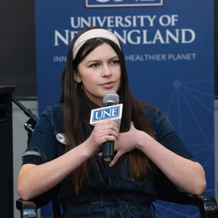 Student asking a question into a microphone at the climate teach-in
