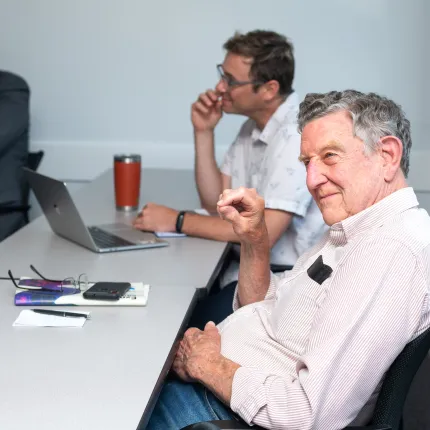 Faculty members watch student presentations from the classroom seats