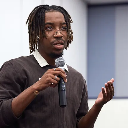 A UNE student stands and asks a question to the pannel of speakers