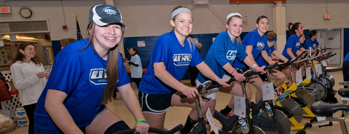 A row of students biking on stationary bikes during a Cycle for Life event