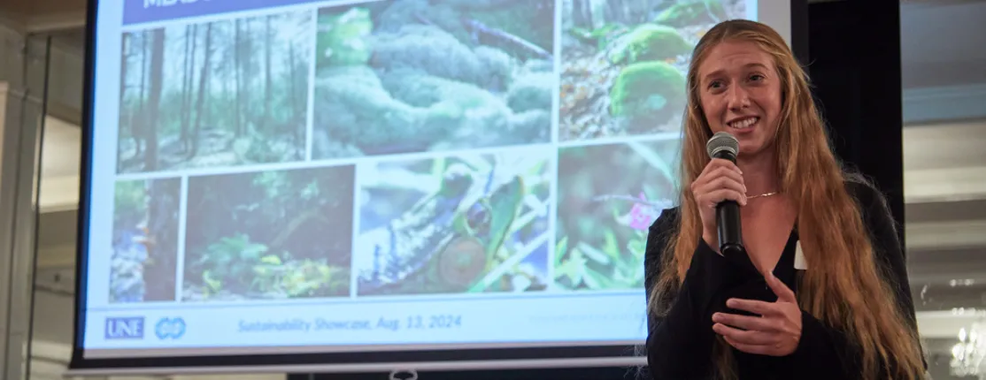 A student gives a presentation about the meadow woods preserve on a projection screen