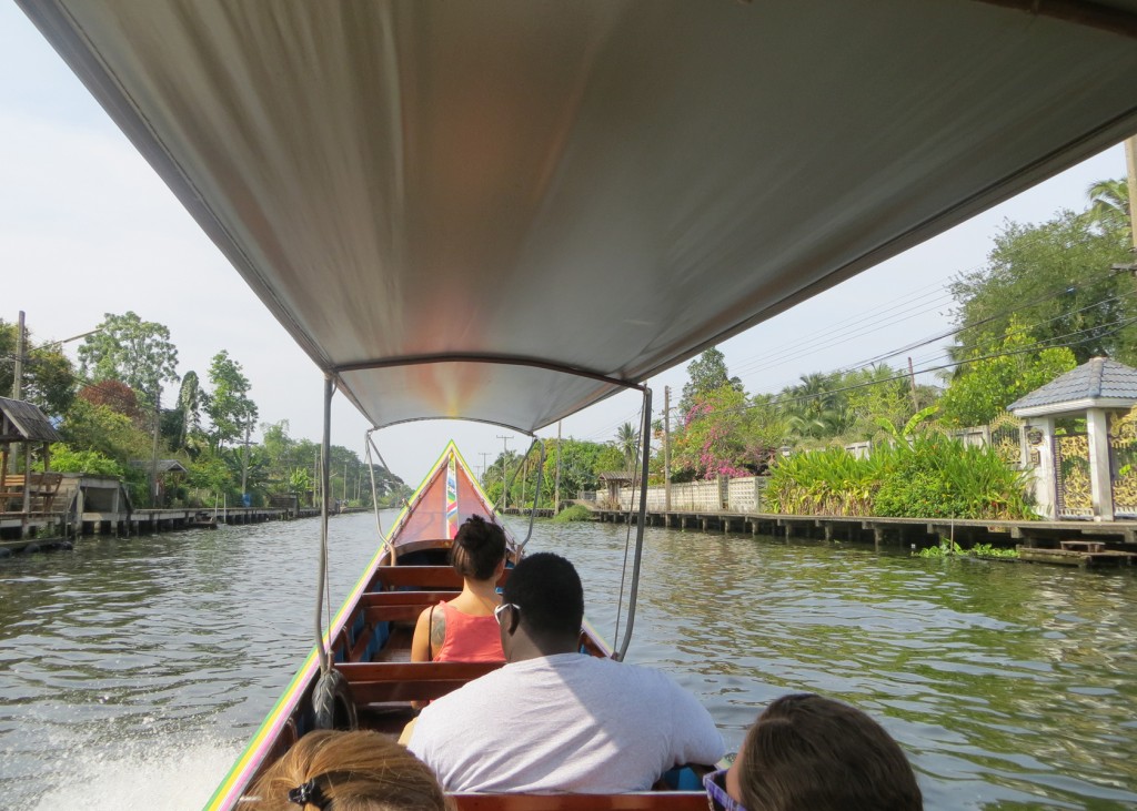 a u n e student rides a longboat in thailand