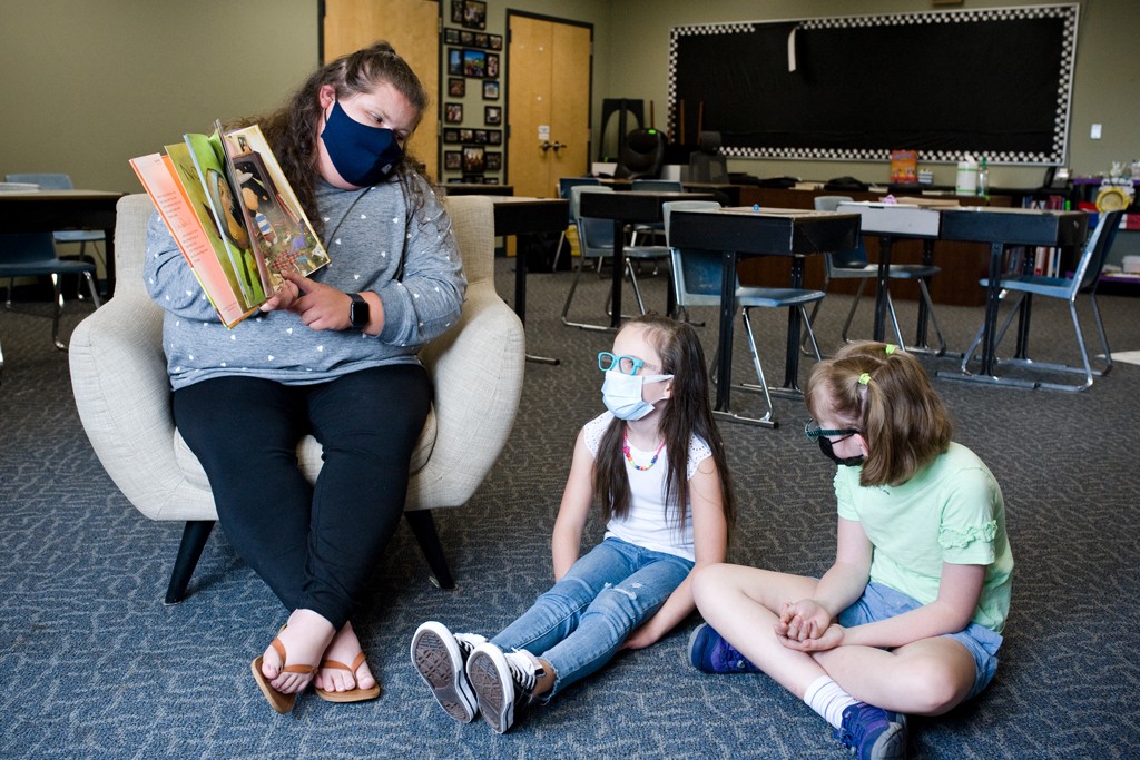A U N E students reads to two elementary school special education students