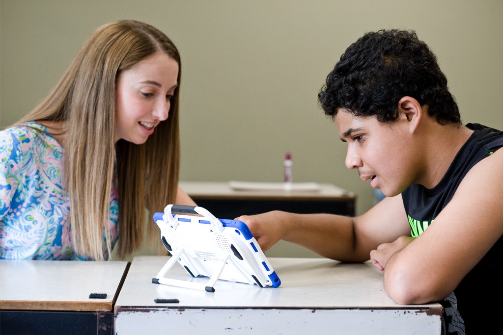 A U N E student works with a special education student