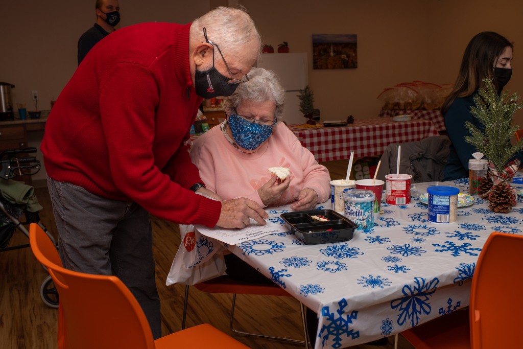 Two older adults decorate Christmas cookies
