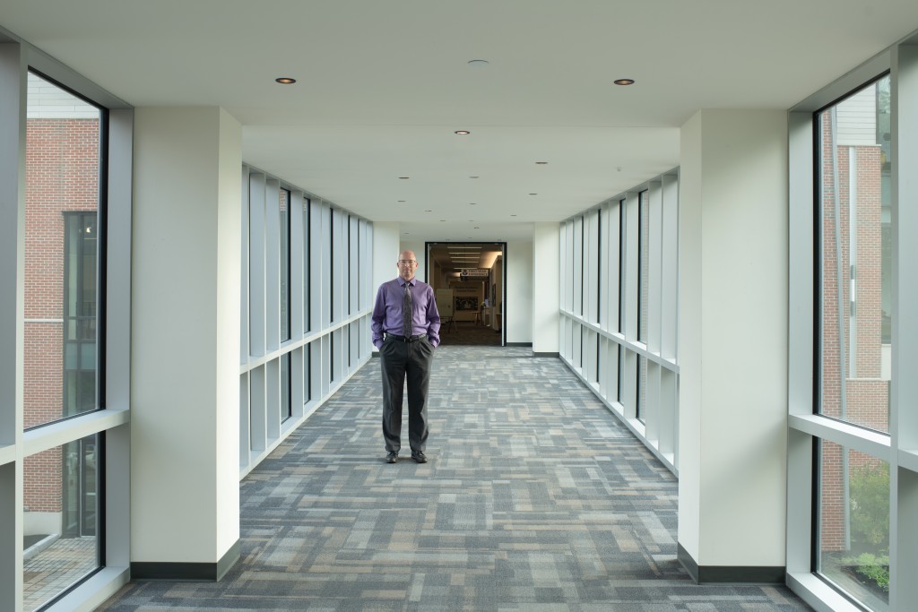 Portrait of Marc Ebenfield standing in a hallway