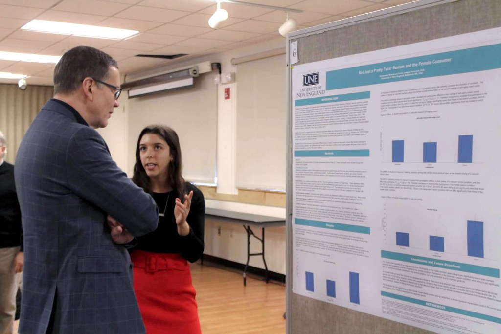 Deveau shows off the results of her preliminary study to UNE President James Herbert at the fall 2018 SURE Symposium. Her poster