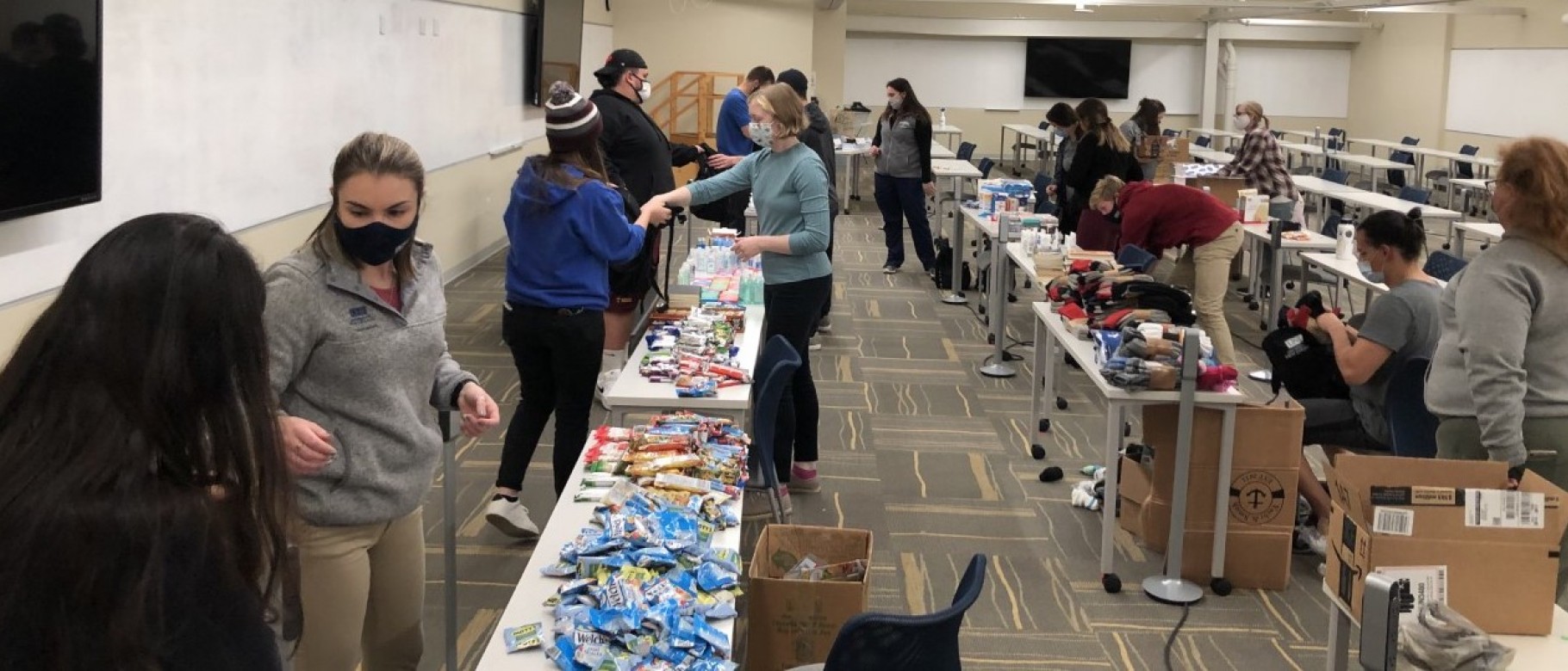A group of students from UNE's Nursing, Pharmacy, Occupational Therapy, and Pharmacy programs packs backpacks for Milestone Recovery clients on Nov. 5.