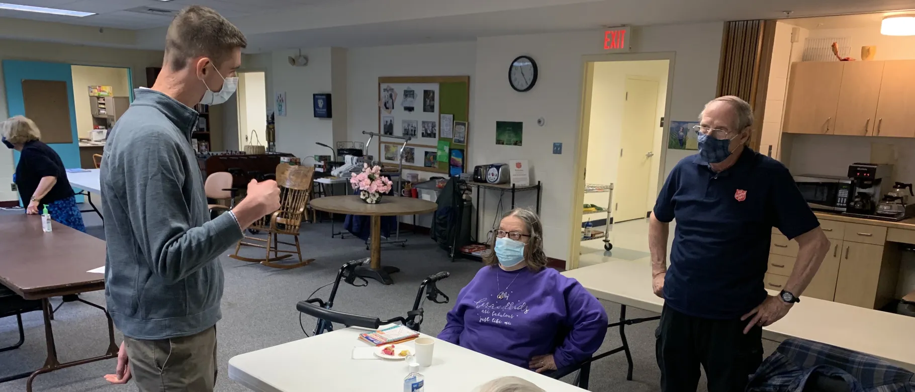 UNE student Topher Van Hare talks with seniors at The Salvation Army