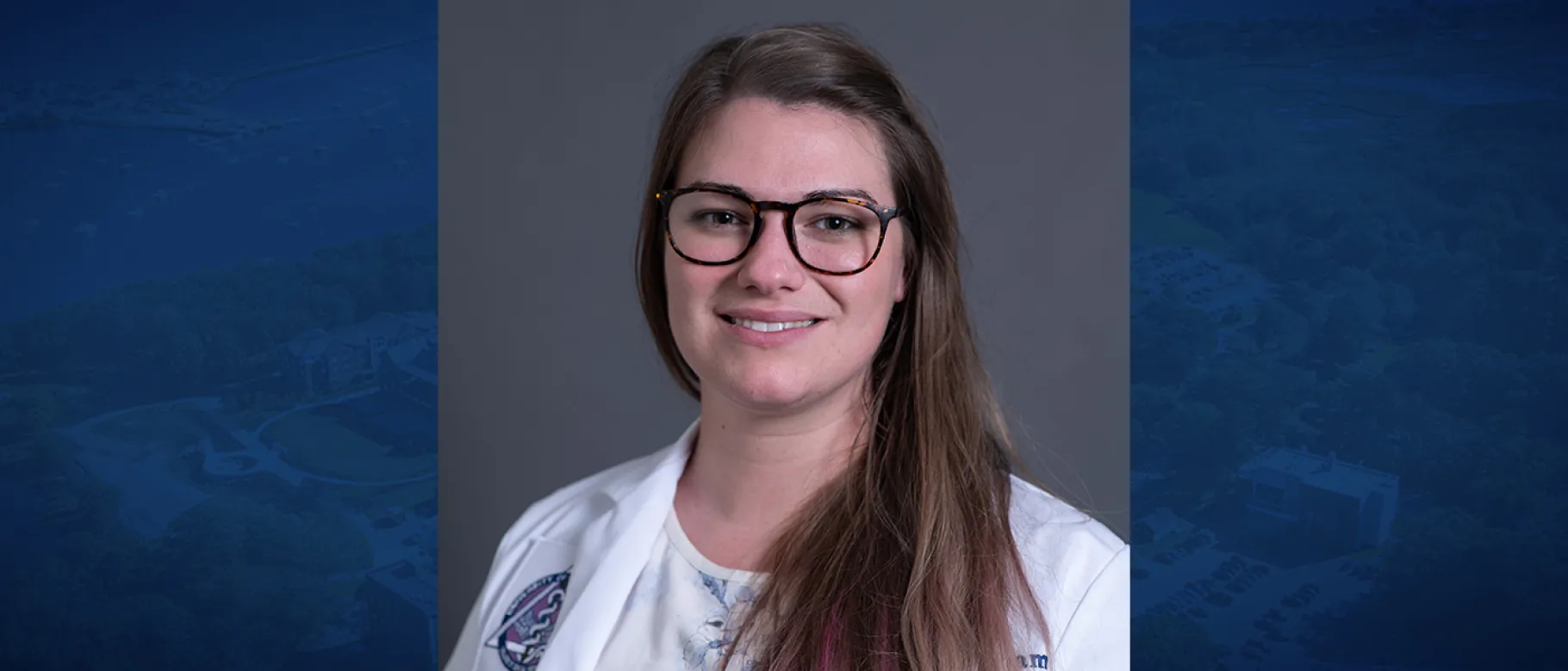 Portrait of woman smiling, wearing glasses, with white lab coat