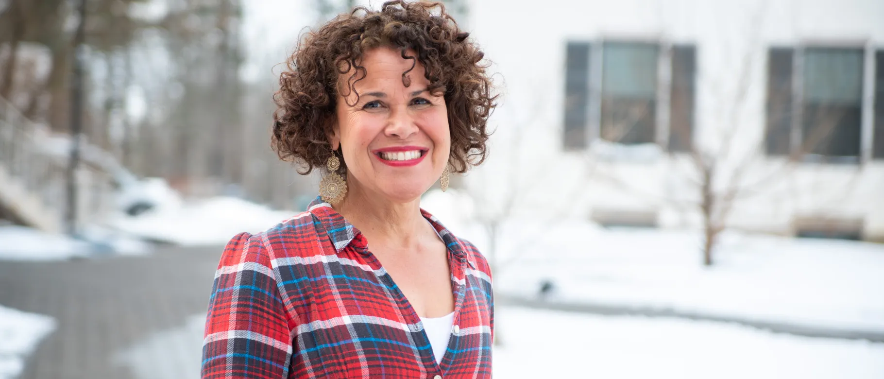 Photo of UNE faculty Arabella Perez smiling with Portland Campus in background