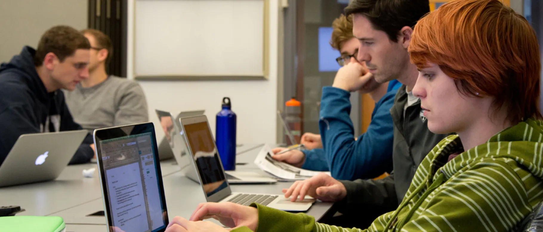 Students taking notes on their laptops during class lecture