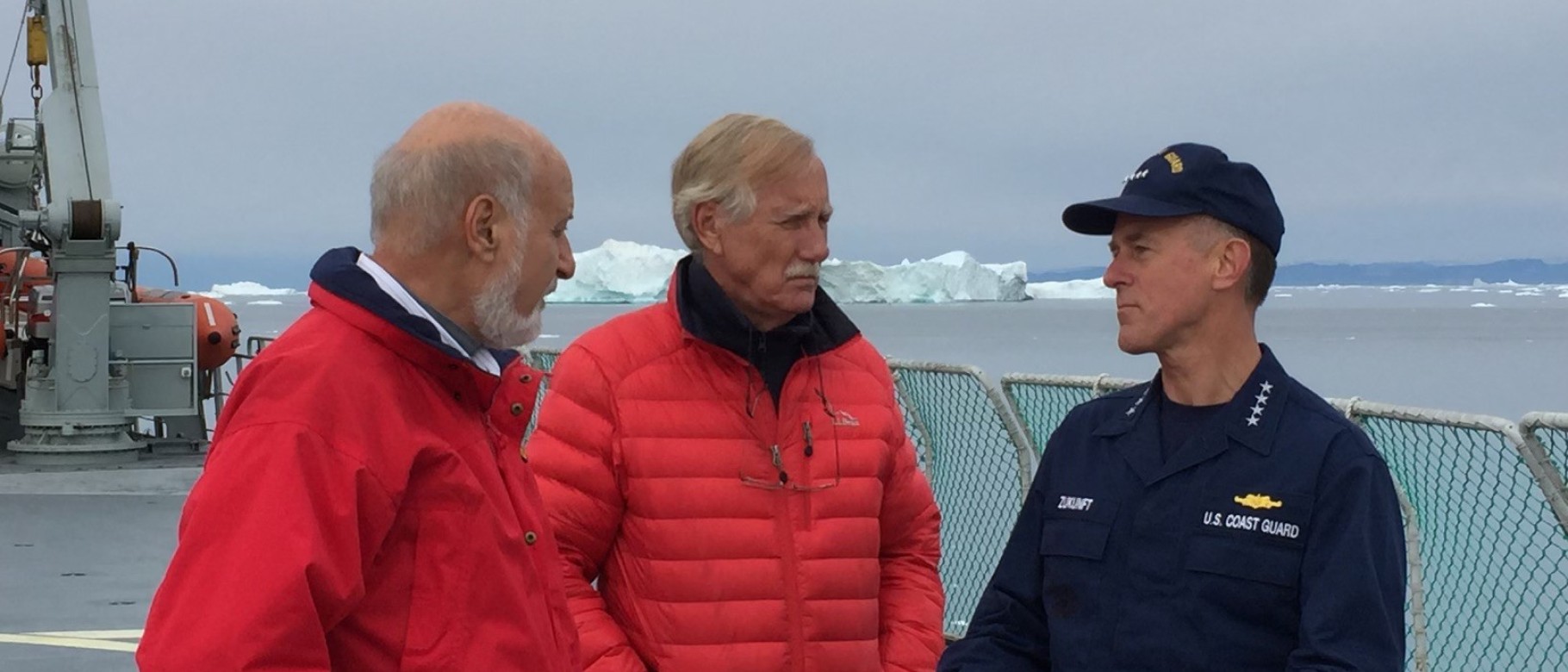Sen. Angus King of Maine stands with a member of the U.S. Coast Guard on a Coast Guard boat