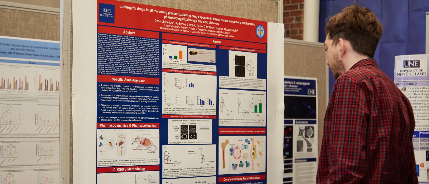 A student reads a research poster at the first annual symposium on biomedical research and engineering