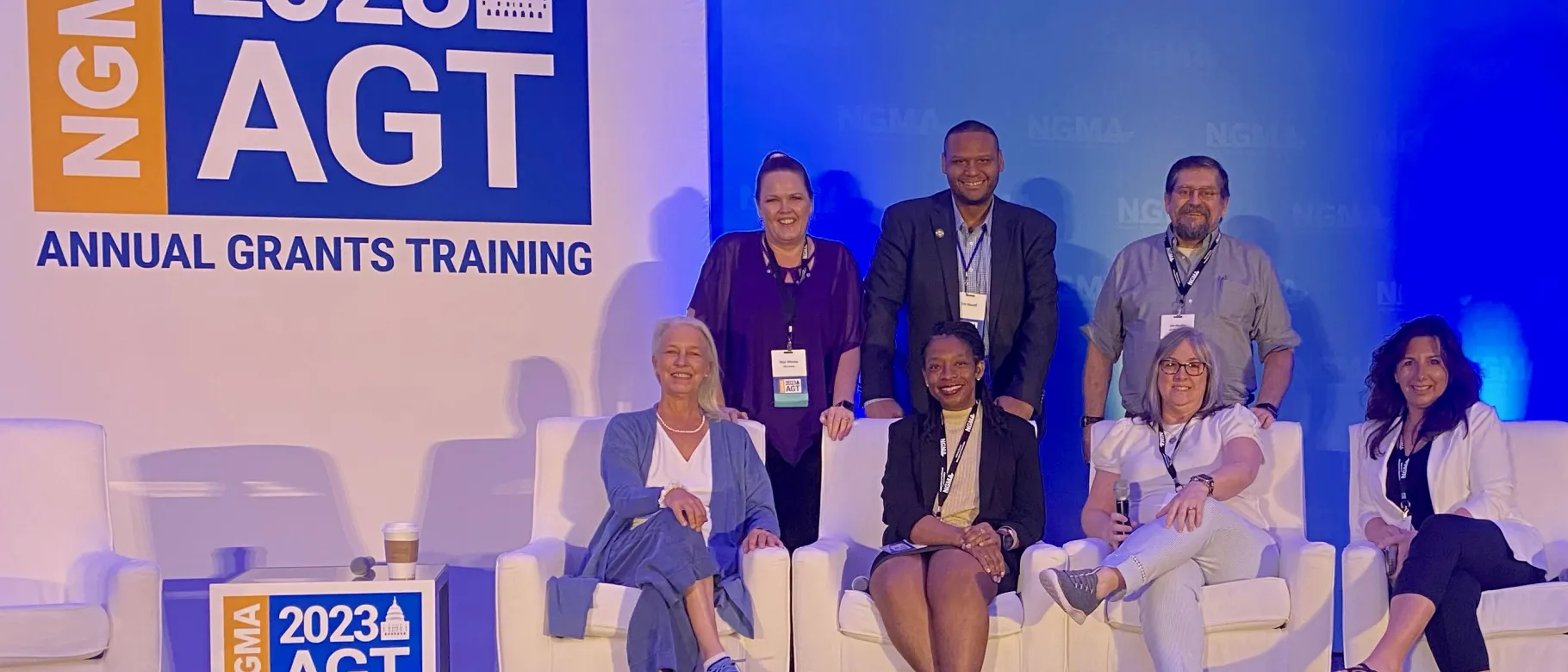 A group of men and women pose for a photo at a conference
