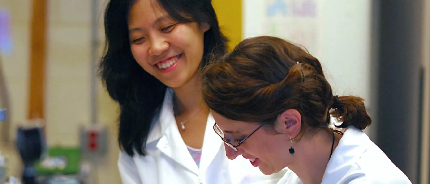 Ling Cao assists a student in a research lab